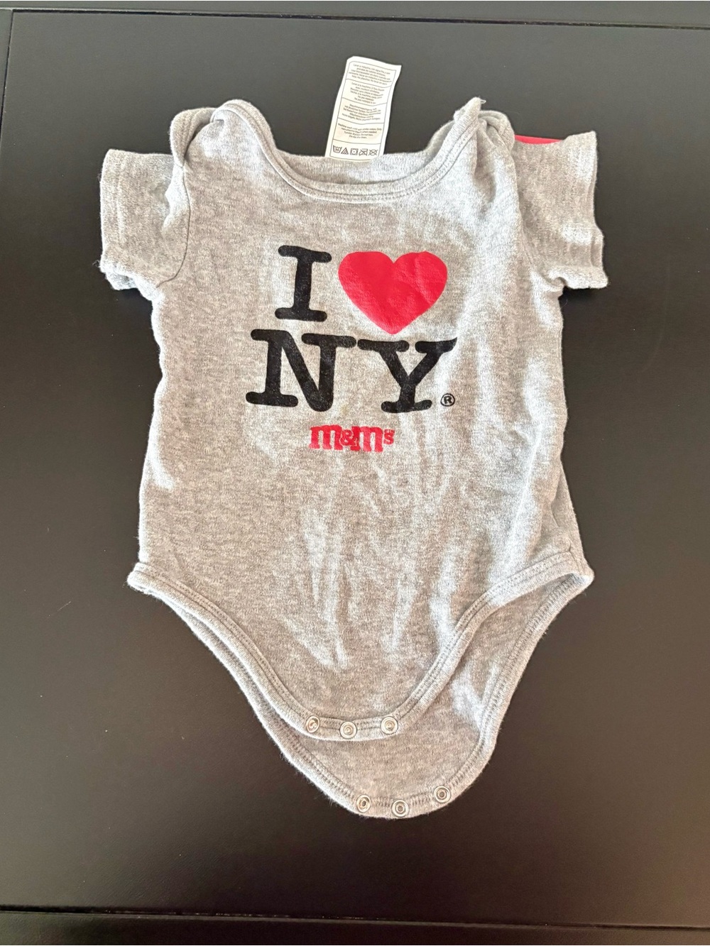M&M'S Gray One-Piece Bodysuit with Red Heart and Black Lettering